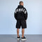 Zwarte oversized hoodie met capuchon en gebogen witte tekst op de rug.