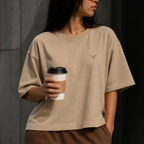 Zandkleurig boxy cropped T-shirt met ronde hals en klein borstlogo.