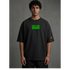 Zwarte t-shirt met groene geborduurde tekst op borst en klein logo rechts
