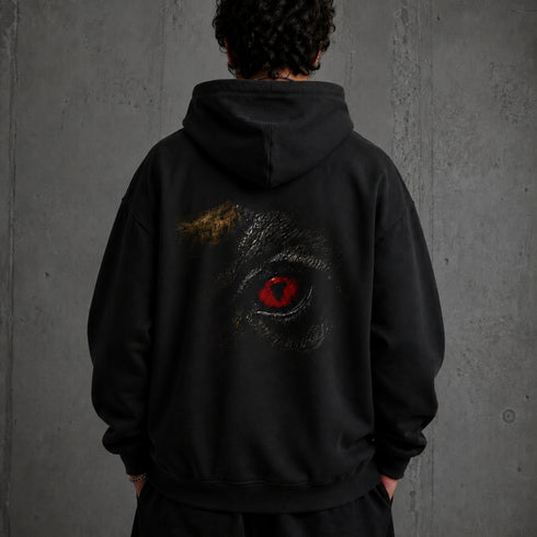 Zwarte hoodie met capuchon en grote zwarte-rondom oogprint op de rug.