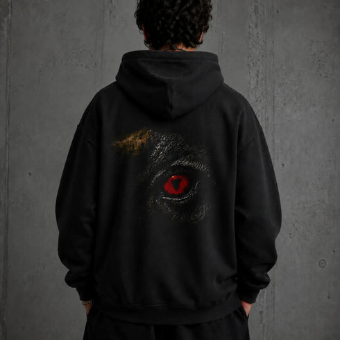 Zwarte hoodie met capuchon en grote zwarte-rondom oogprint op de rug.