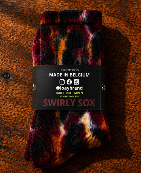 Tie-dye sok zwart-bordeaux-oranje met Swirly Sox etiket 'MADE IN BELGIUM'.