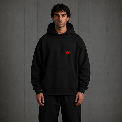 Zwarte oversized hoodie met capuchon en kleine rode borstprint.